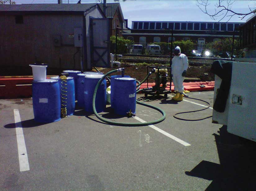 Blue waste barrels with person in Hazmat suit