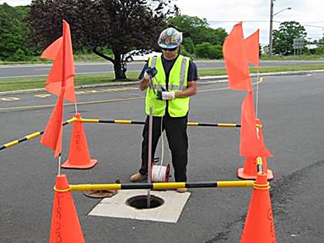 Technician gauging a well