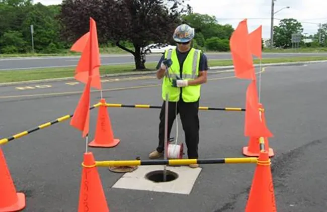 Technician gauging a well